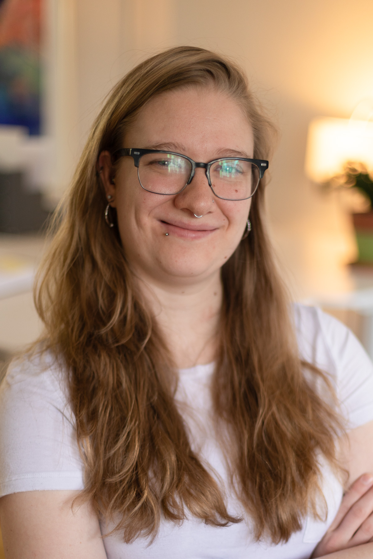 A young female professional mixed media specialist at Circuit Media, smiling and wearing a white t-shirt