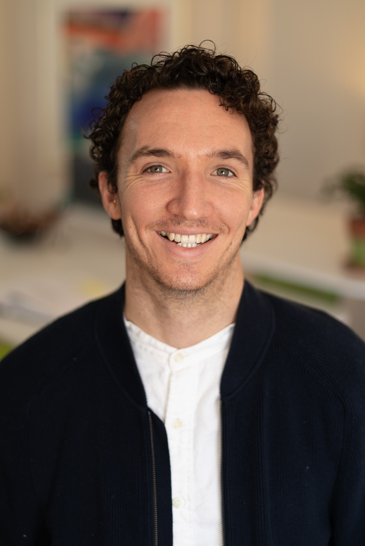 A young male professional creative at Circuit Media, smiling and wearing a white button up